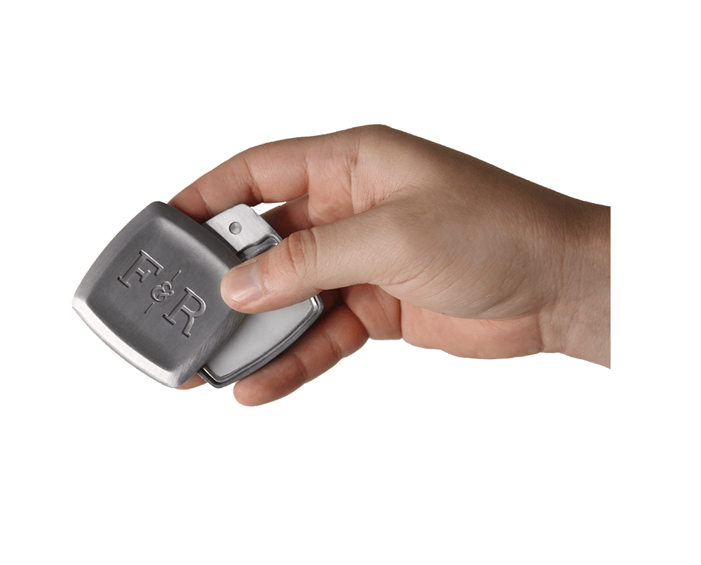 Hand holding a half open Fulton & Roark solid fragrance